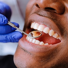 a man having his teeth examined by a dentist