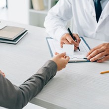 Woman giving health insurance card to care provider