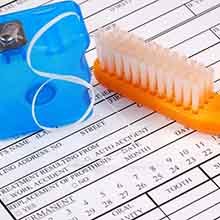 Toothbrush and floss on dental insurance form